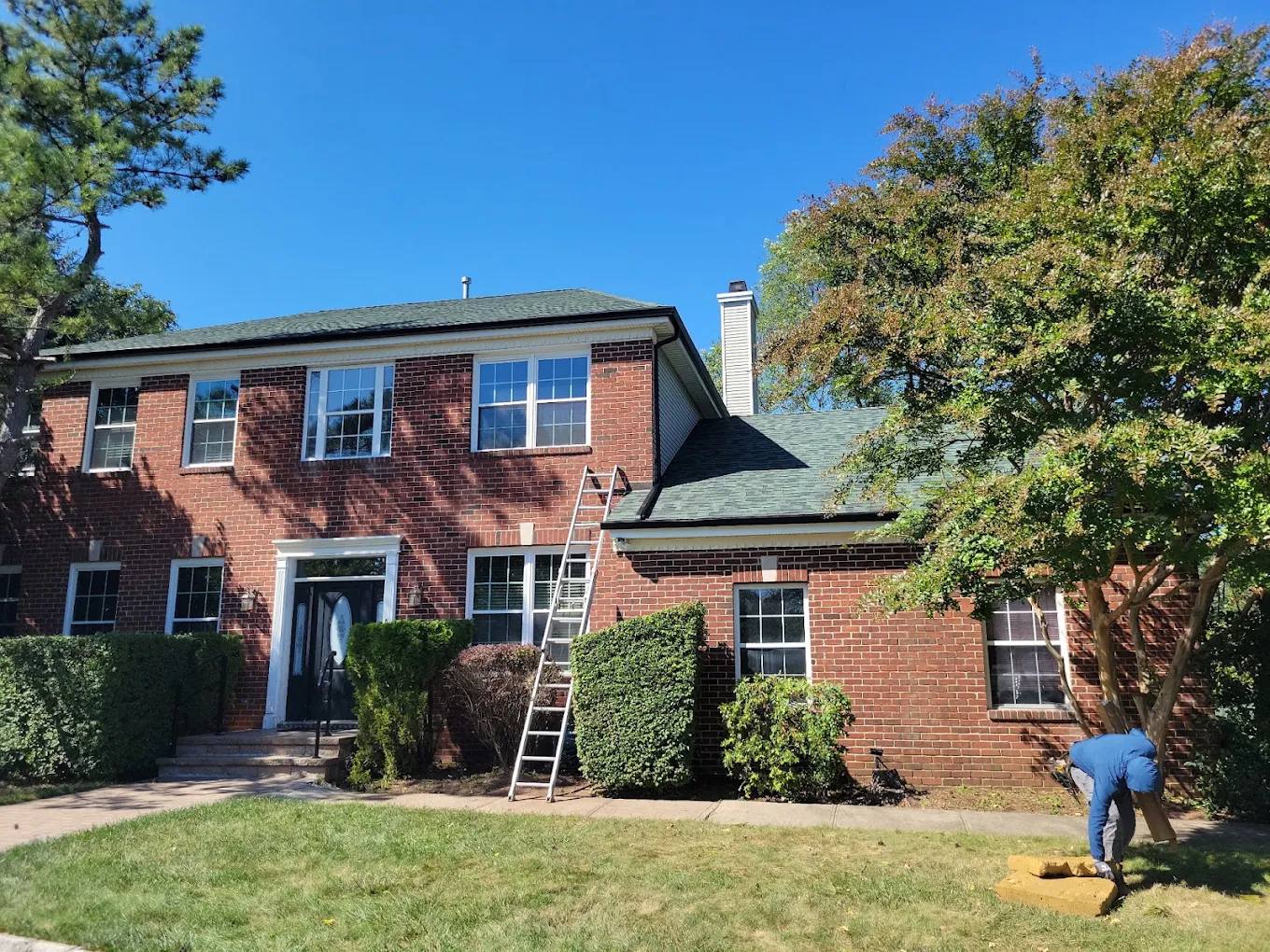 Brick colonial home with a new green shingle roof