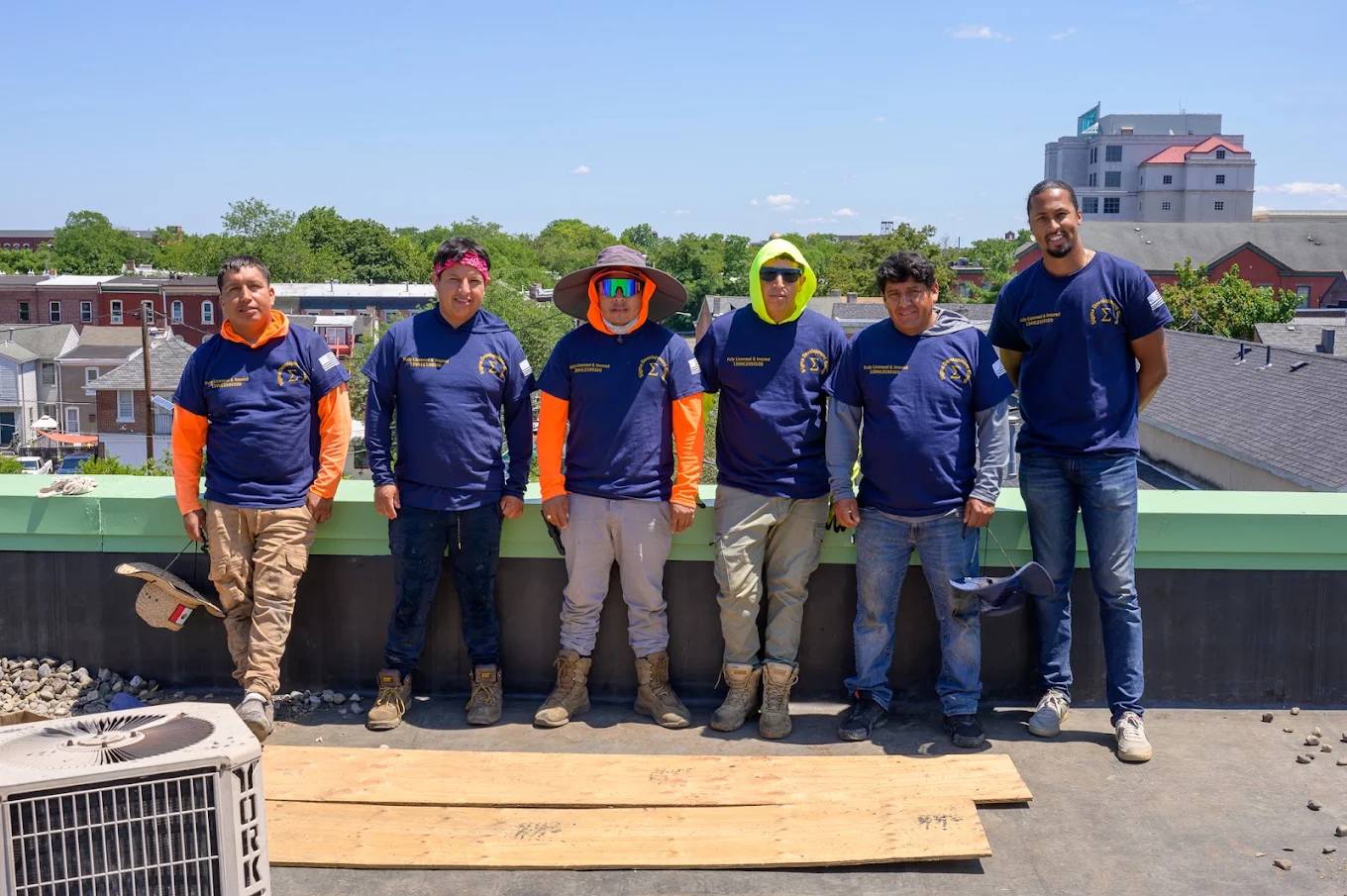 The Sigma Solar & Roofing crew in navy company shirts on a rooftop job site