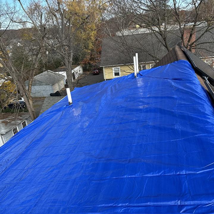 Emergency tarp secured over a storm-damaged roof