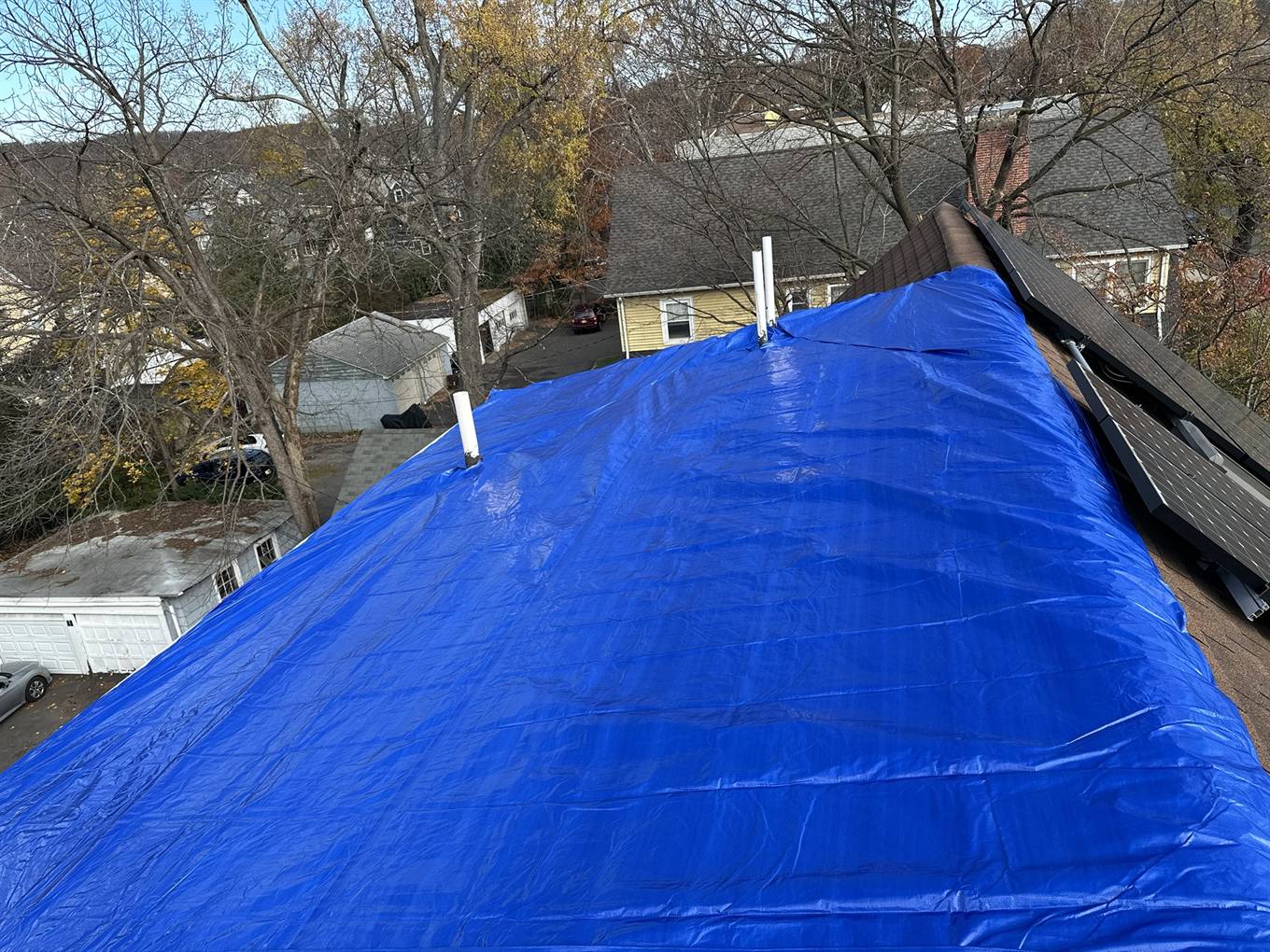 Emergency tarp protecting a roof after storm damage